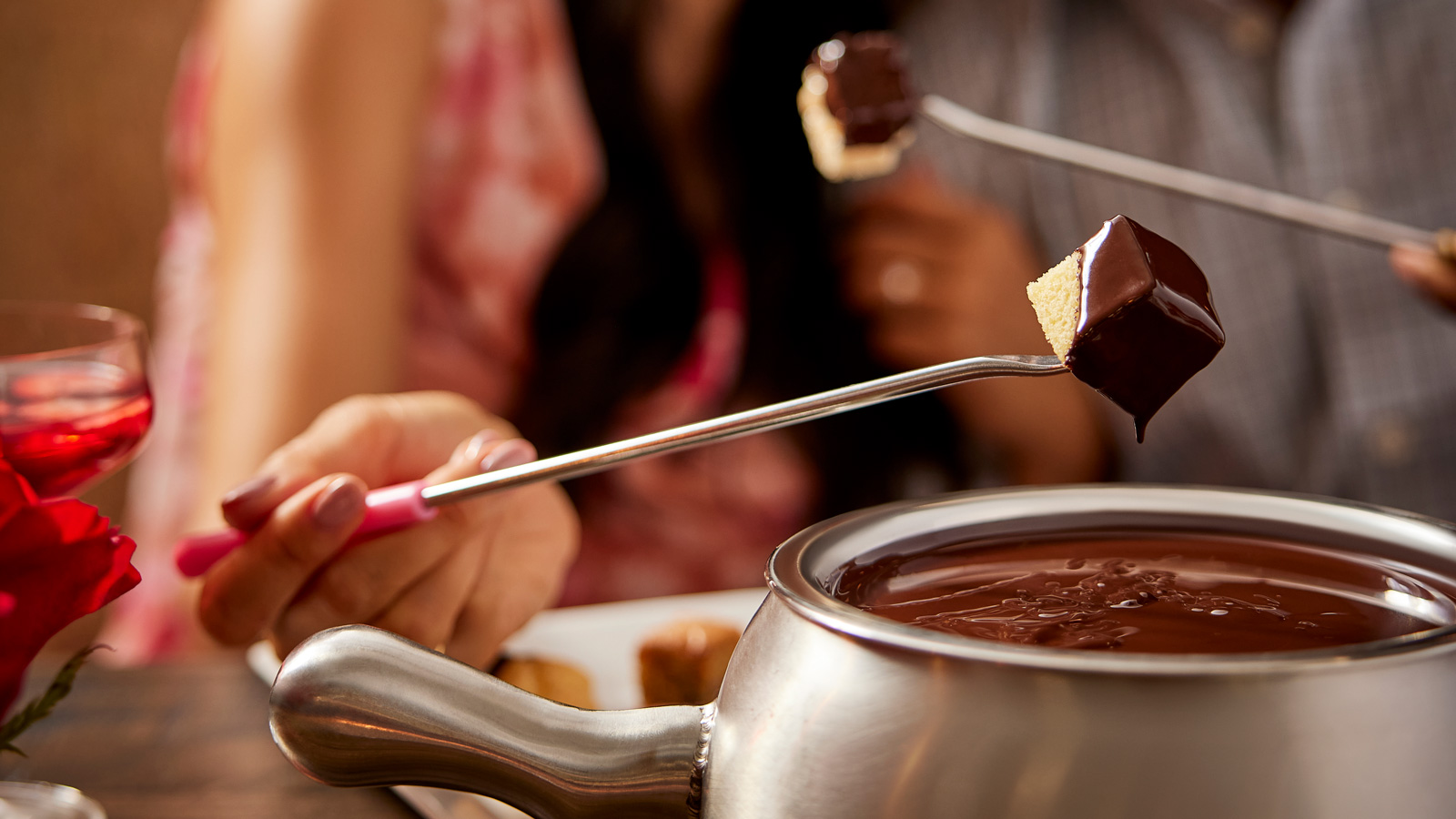 a person dipping chocolate into a pot
