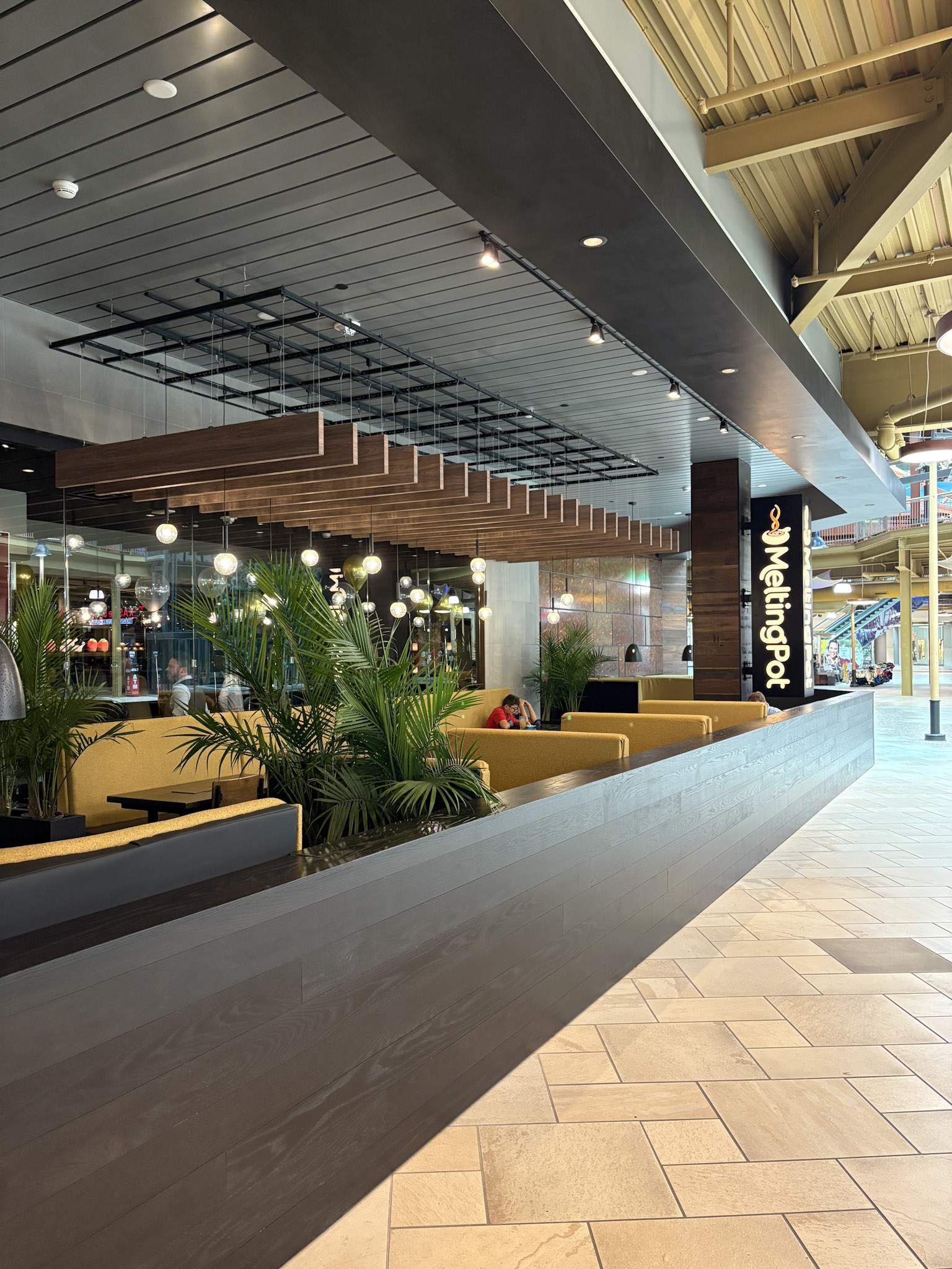 a restaurant with a long wall and plants