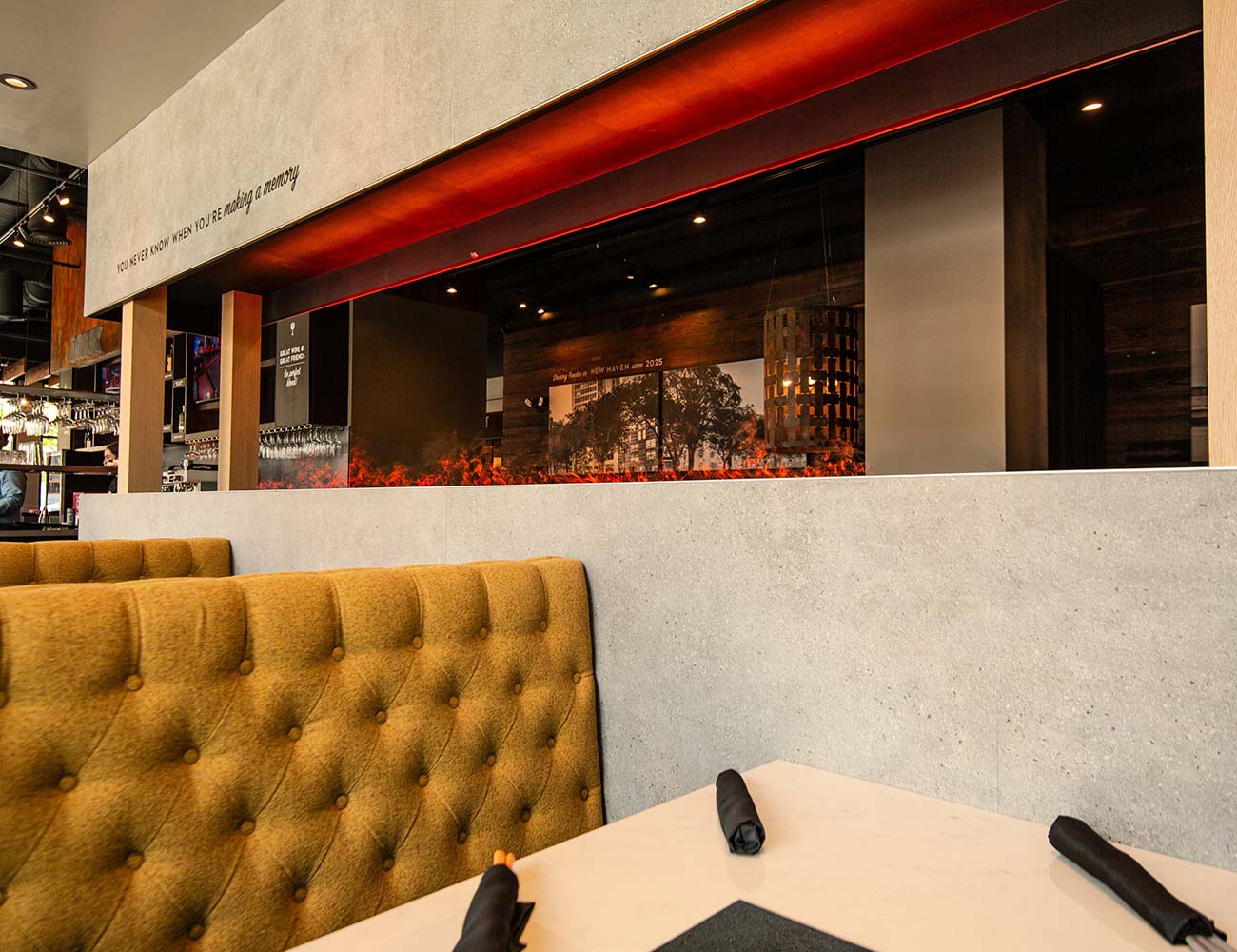 A cozy table set beside a modern, accent wall in Melting Pot New Haven, CT.